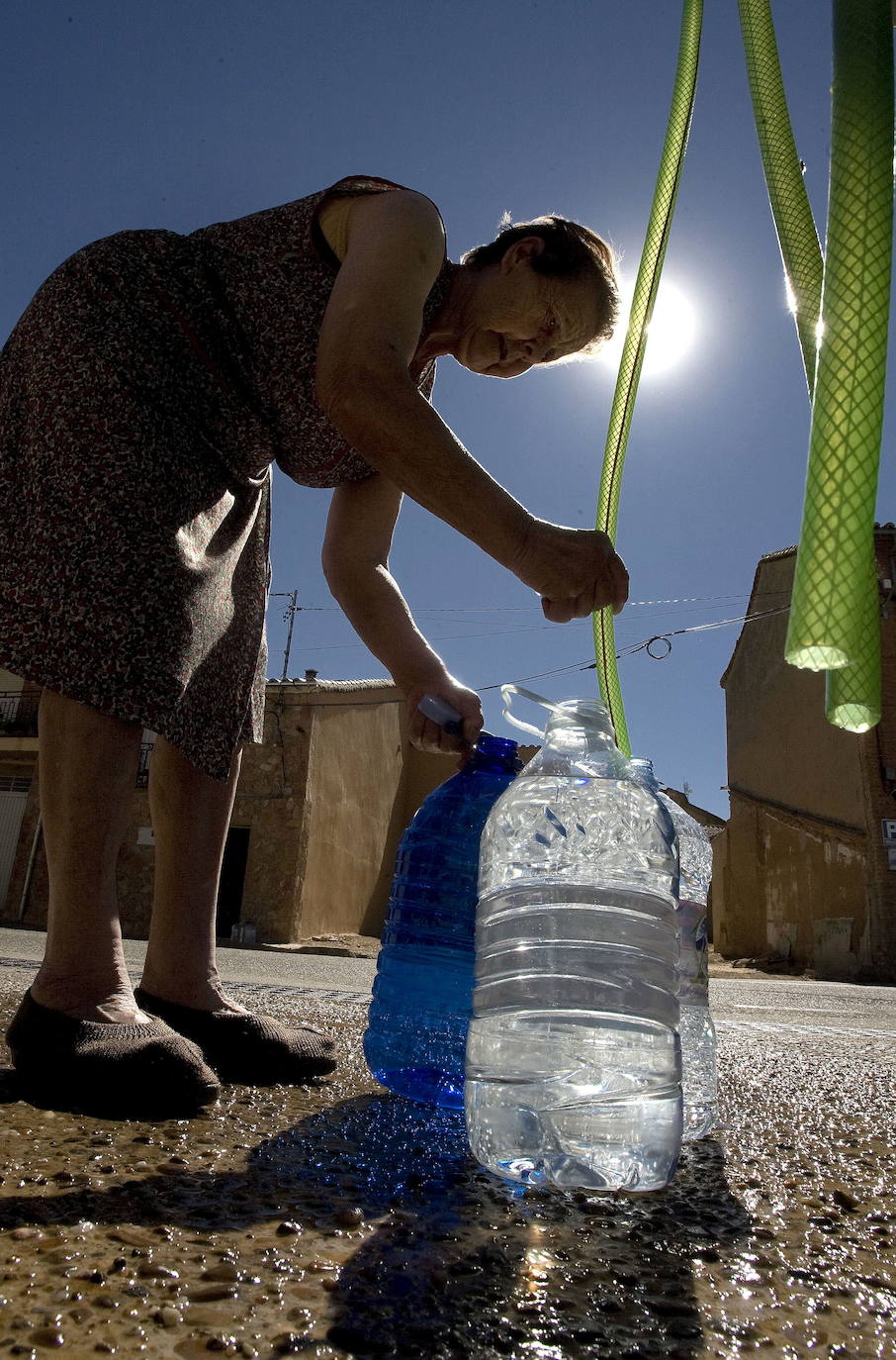 Una vecina llena garrafas de agua procedente de un camión cisterna en un pueblo castellanoleonés. 