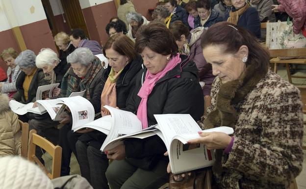 Las personas mayores ojean el libro de recetas. 