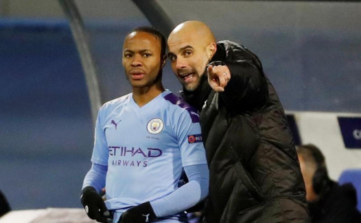 Pep Guardiola habla con Raheem Sterling durante un partido del Manchester City. 