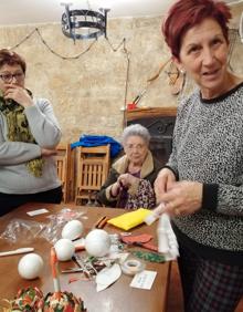 Imagen secundaria 2 - Nati, en la última foto, ha enseñado a sus vecinos a elaborar bolas navideñas de decoración. En otra foto, todos los vecinos de Santa Gadea que han participado en el curso de capacitación posan con sus diplomas. 
