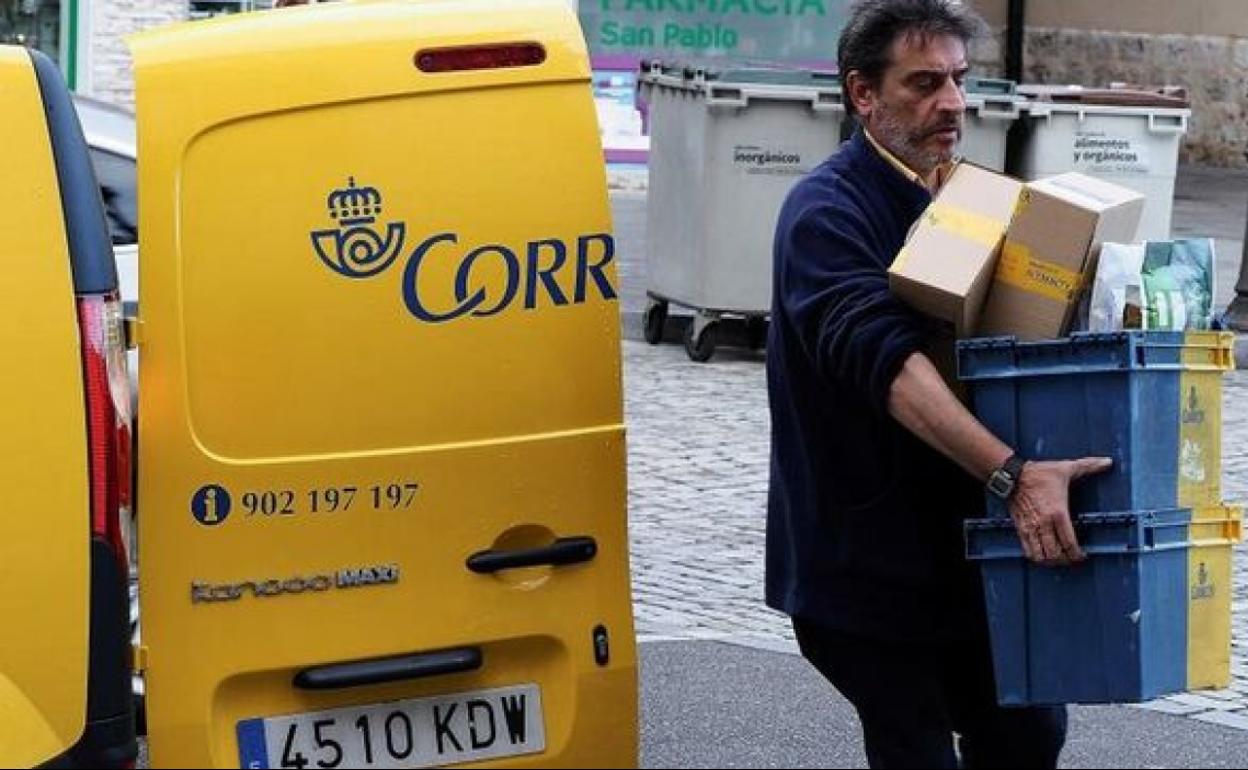 Un empleado de Correos entrega unos paquetes.