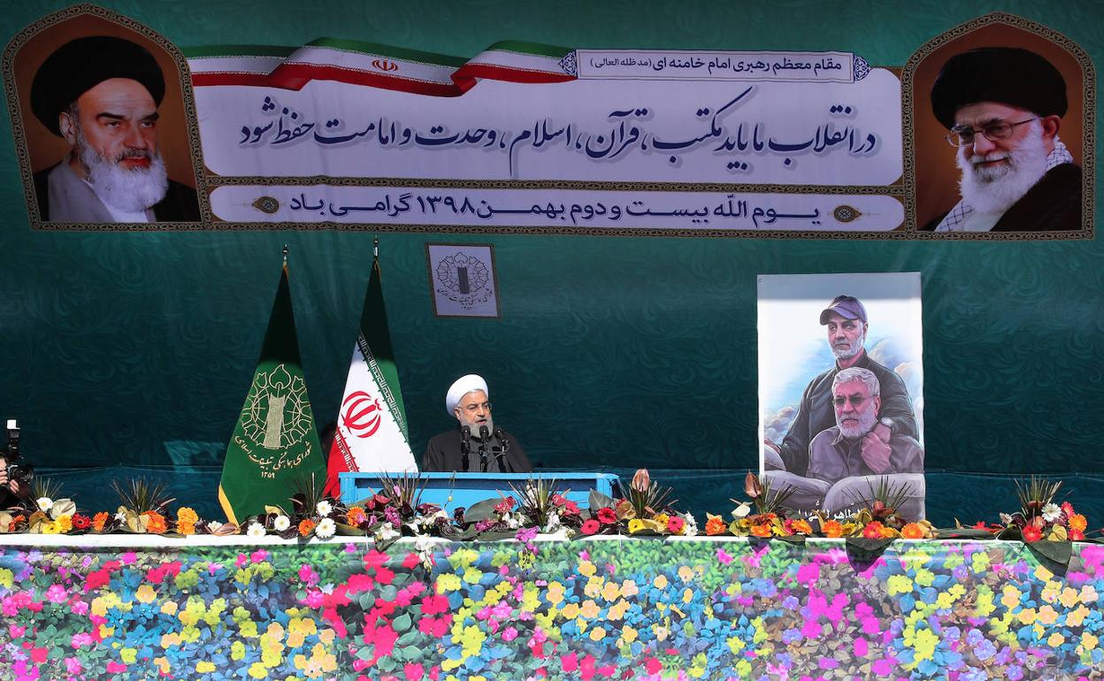 Hasán Rohani se dirige a los ciudadanos en el 41 aniversario de la revolución islámica, junto a una fotografía del general Qasem Soleimani.