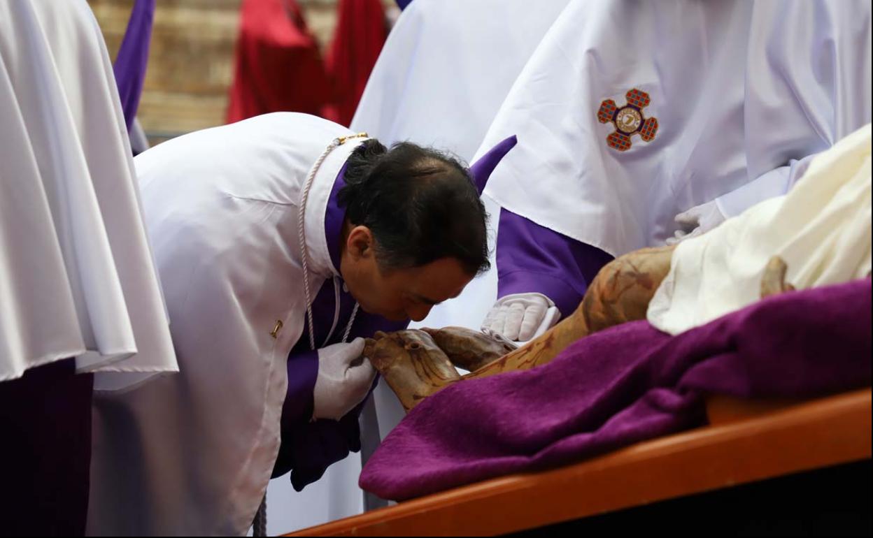 Un cofrade besa los pies del Santísimo Cristo de Burgos durante la procesión del Acto del Desenclavo de la Cruz del año pasado.