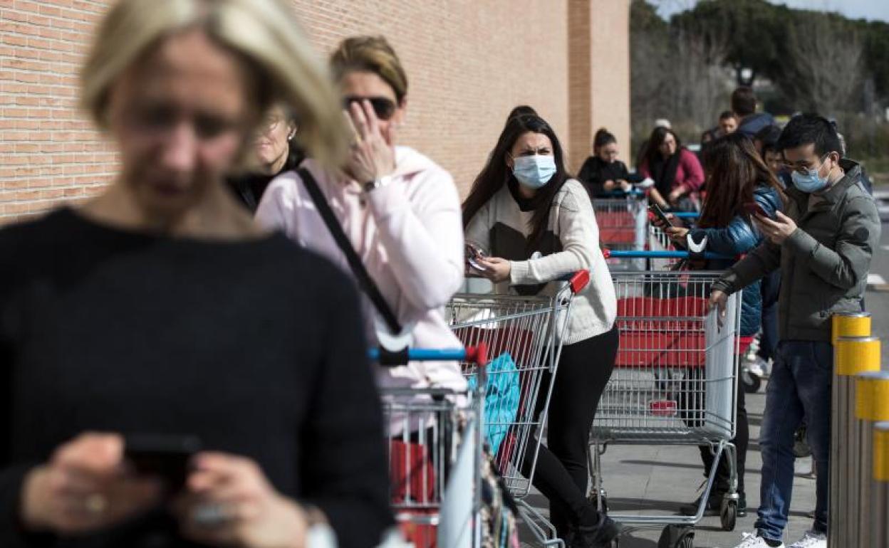 Ciudadanos hacen cola en un Supermercado de Brescia (Italia) 