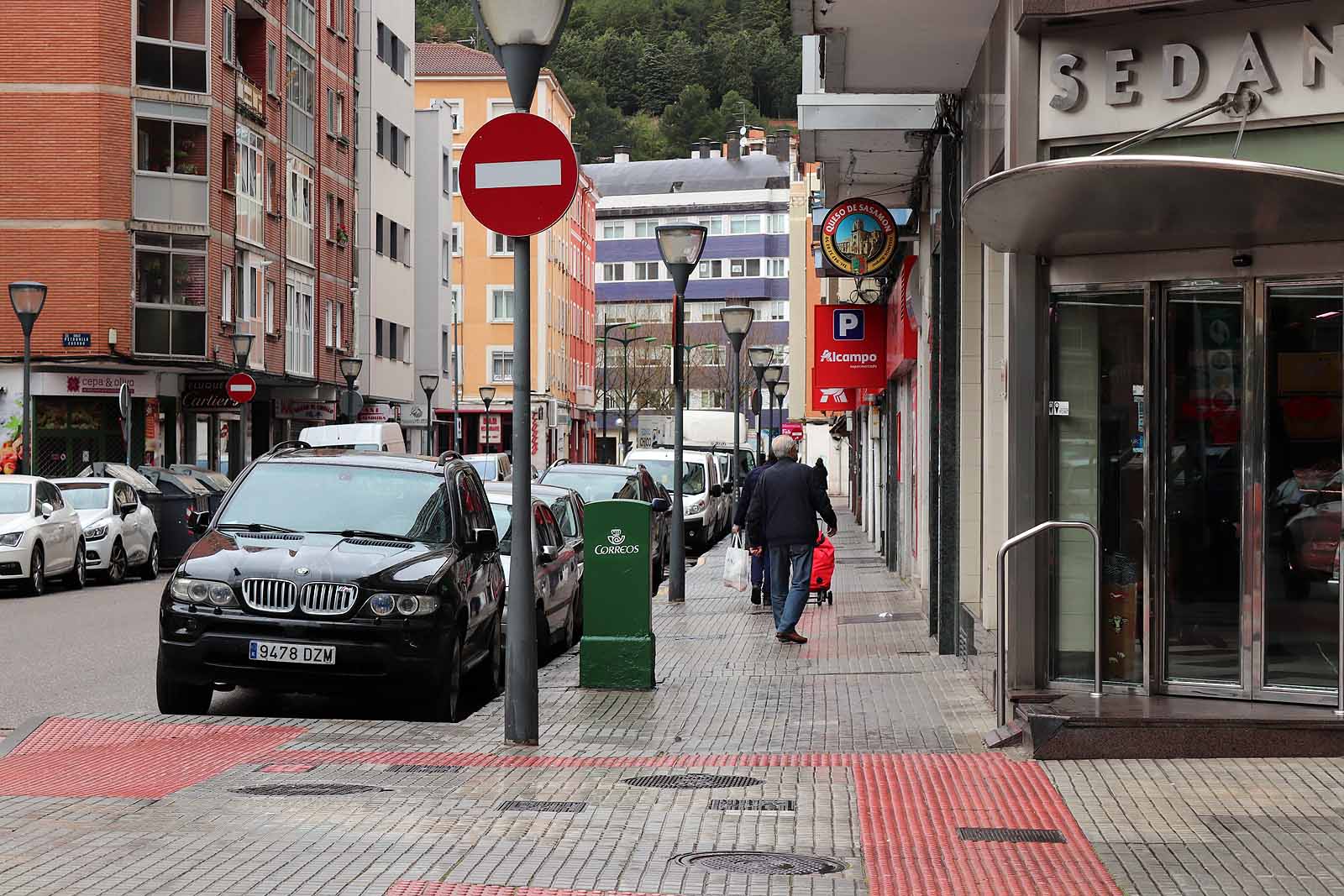 Una vecina consulta una esquela en la calle.