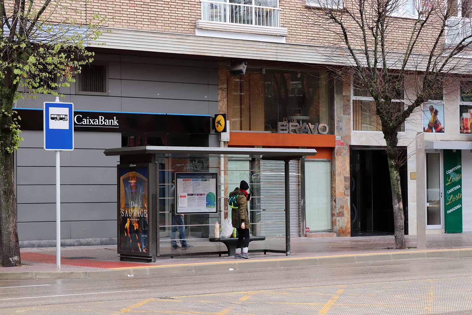 Una vecina consulta una esquela en la calle.