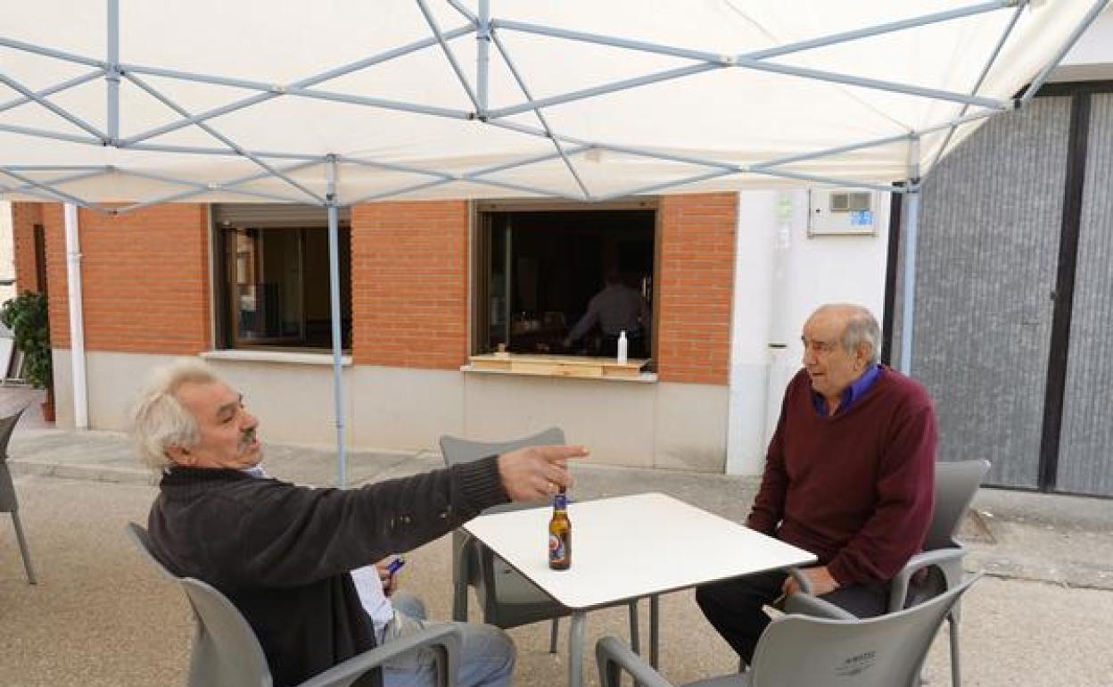 Dos hombres disfrutan de una terraza en la localidad vallisoletana de Esguevillas de Esgueva, en fase 1 desde este lunes.