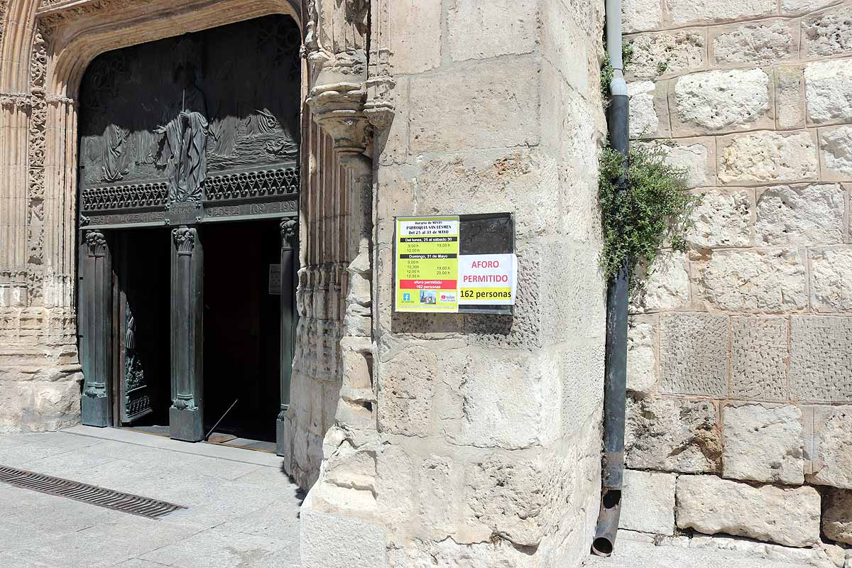 Una mujer se echa gel desinfectante a la entrada de la iglesia deSan Lesmes en Burgos. 