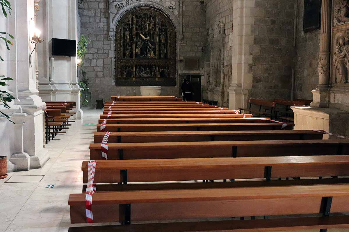 Una mujer se echa gel desinfectante a la entrada de la iglesia deSan Lesmes en Burgos. 