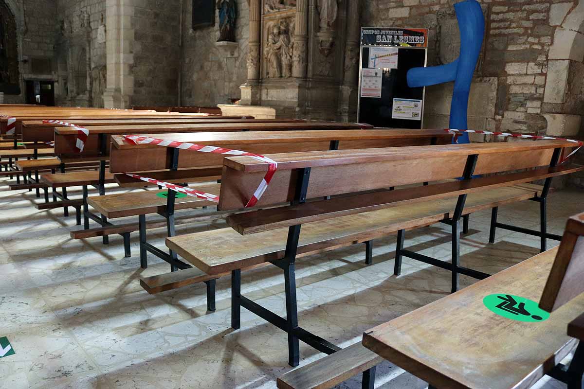 Una mujer se echa gel desinfectante a la entrada de la iglesia deSan Lesmes en Burgos. 