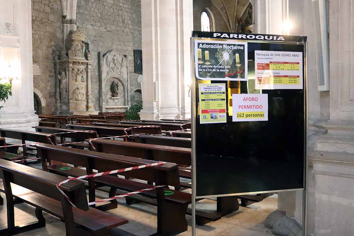 Una mujer se echa gel desinfectante a la entrada de la iglesia deSan Lesmes en Burgos. 