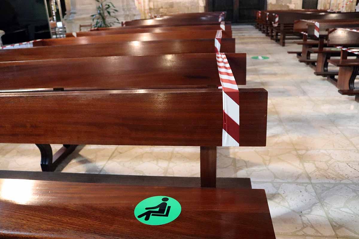 Una mujer se echa gel desinfectante a la entrada de la iglesia deSan Lesmes en Burgos. 