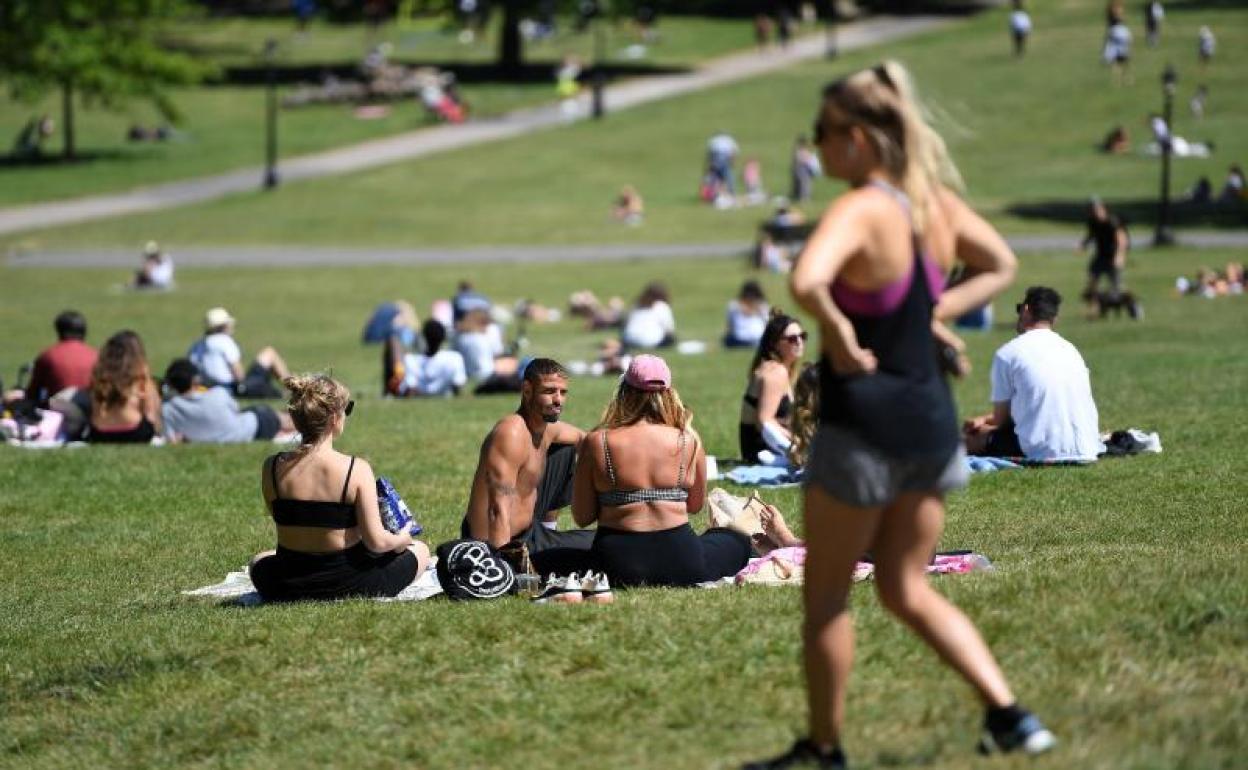 Ciudadanos británicos disfrutan del buen tiempo en un parque de Londres 