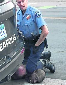 Imagen secundaria 2 - Una manifestante ante la Casa Blanca en Washington se encara con los militares colocados ante la protesta. | Manifestante con una mascarilla con las últimas palabras de Floyd: 'No puedo respirar'. | El policía Derek Chauvin mantuvo inmovilizado así a George Floyd durante más de ocho minutos, hasta que murió.