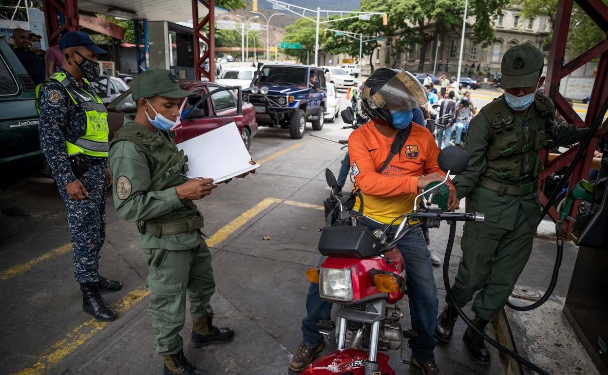 Los venezolanos hacen cola en las gasolineras, muchas reguladas por el ejército, para llenar los depósitos, 