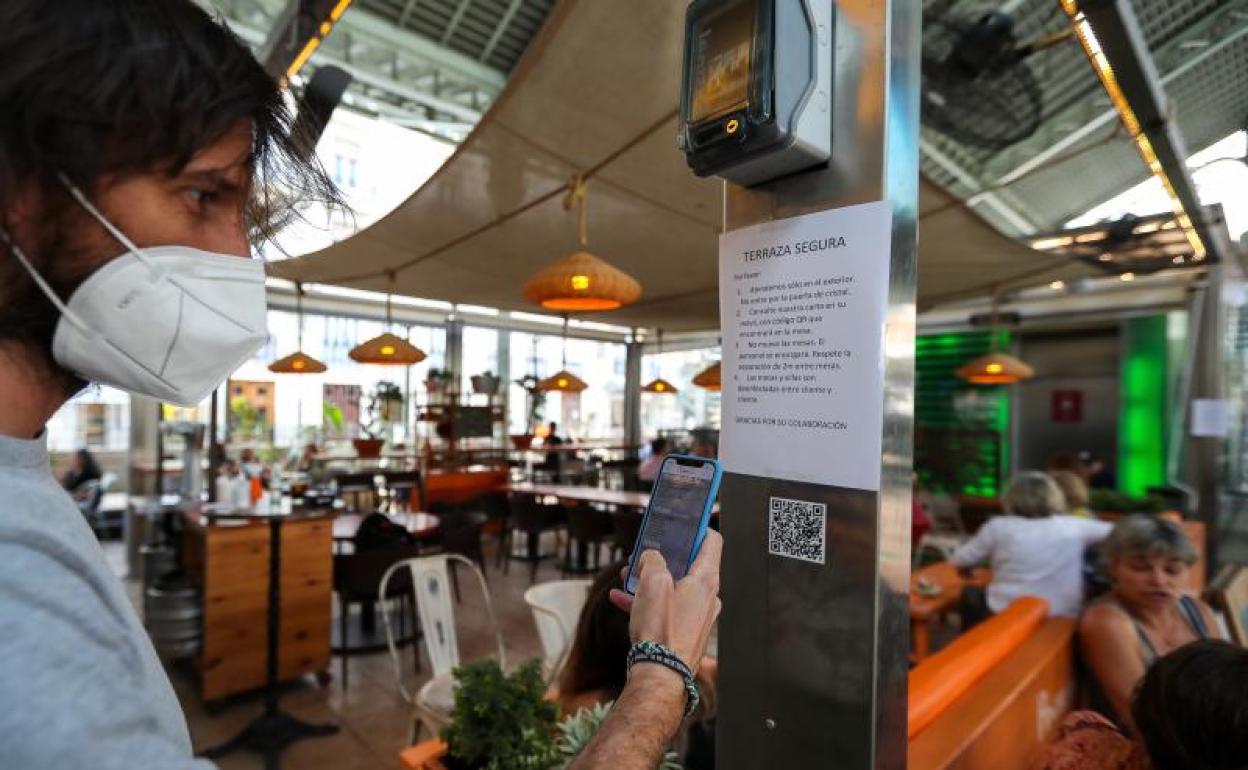 Una persona consulta la carta de productos con código QR en un bar 