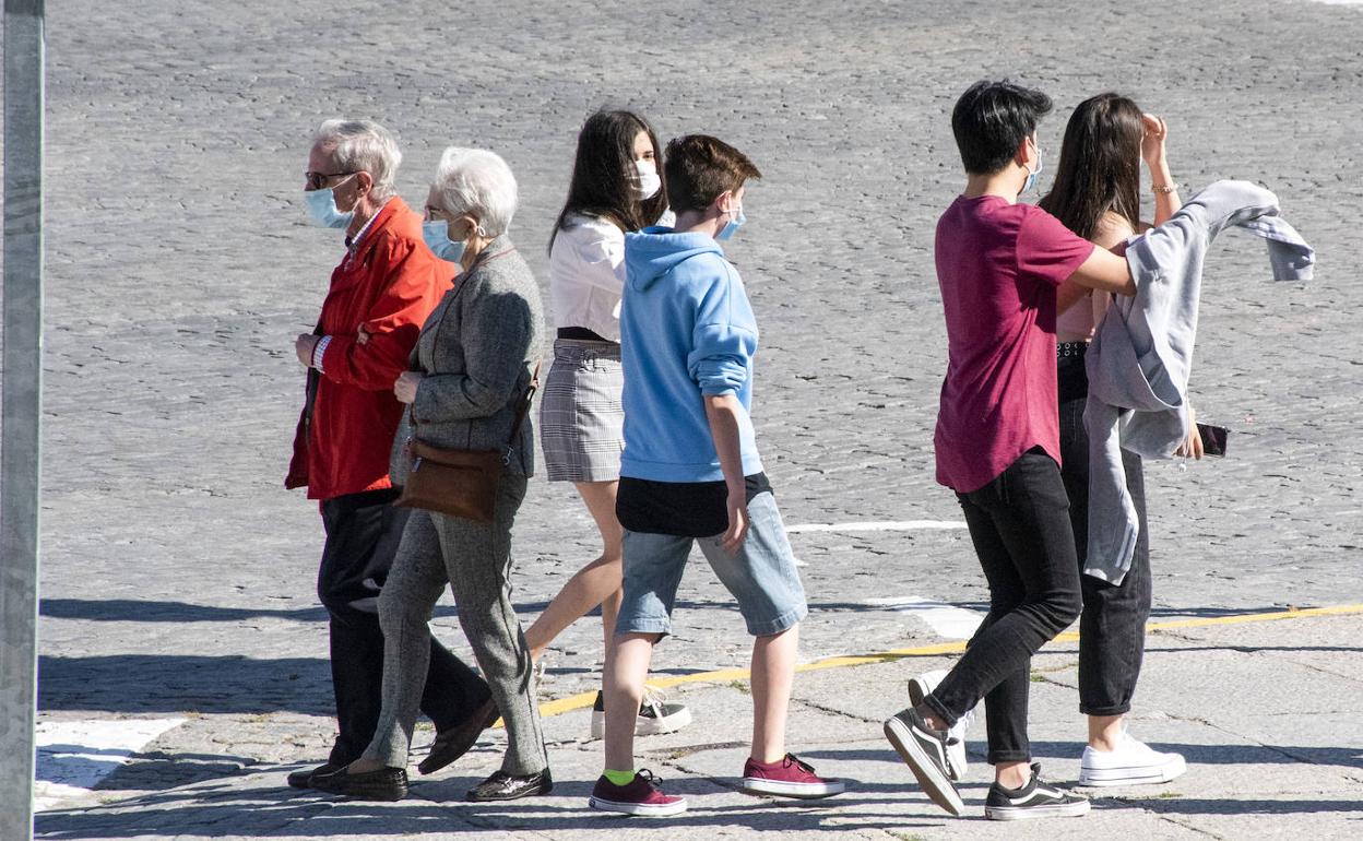 Un grupo de adolescentes se cruza con dos personas mayores, todos con mascarilla, en Segovia. 