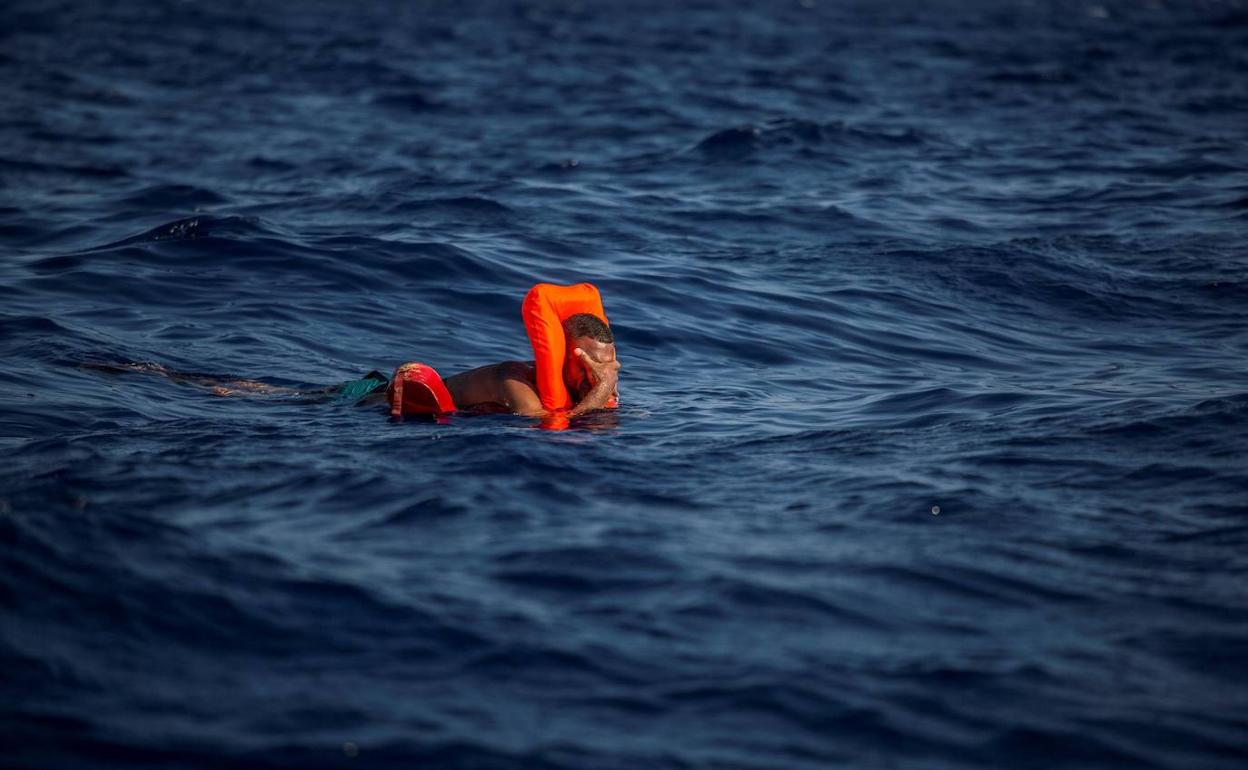 Un hombre, con un chaleco salvavidas proporcionado por voluntarios de Open Arms, flota en el Mediterráneo Central.