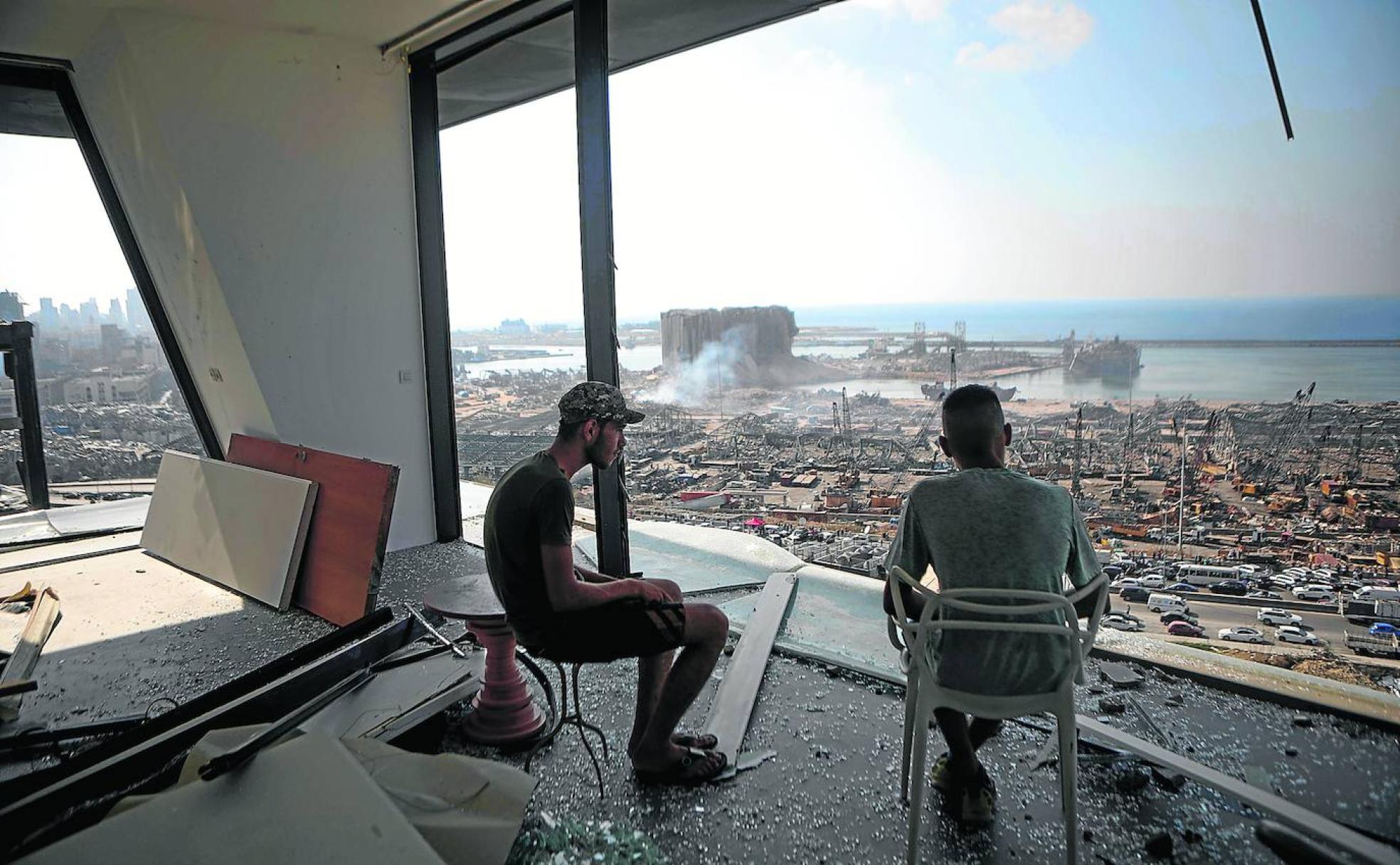 Ruina y destrucción. Dos hombres observan la devastación que dejó el estadillo de 2.700 toneladas de nitrato de amonio en la zona portuaria de la capital del Líbano. 