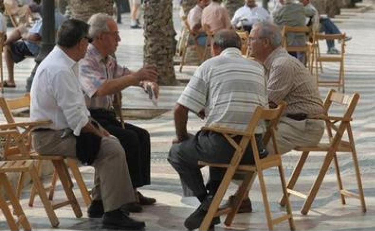 Grupo de pensionistas charlando en un parque. 