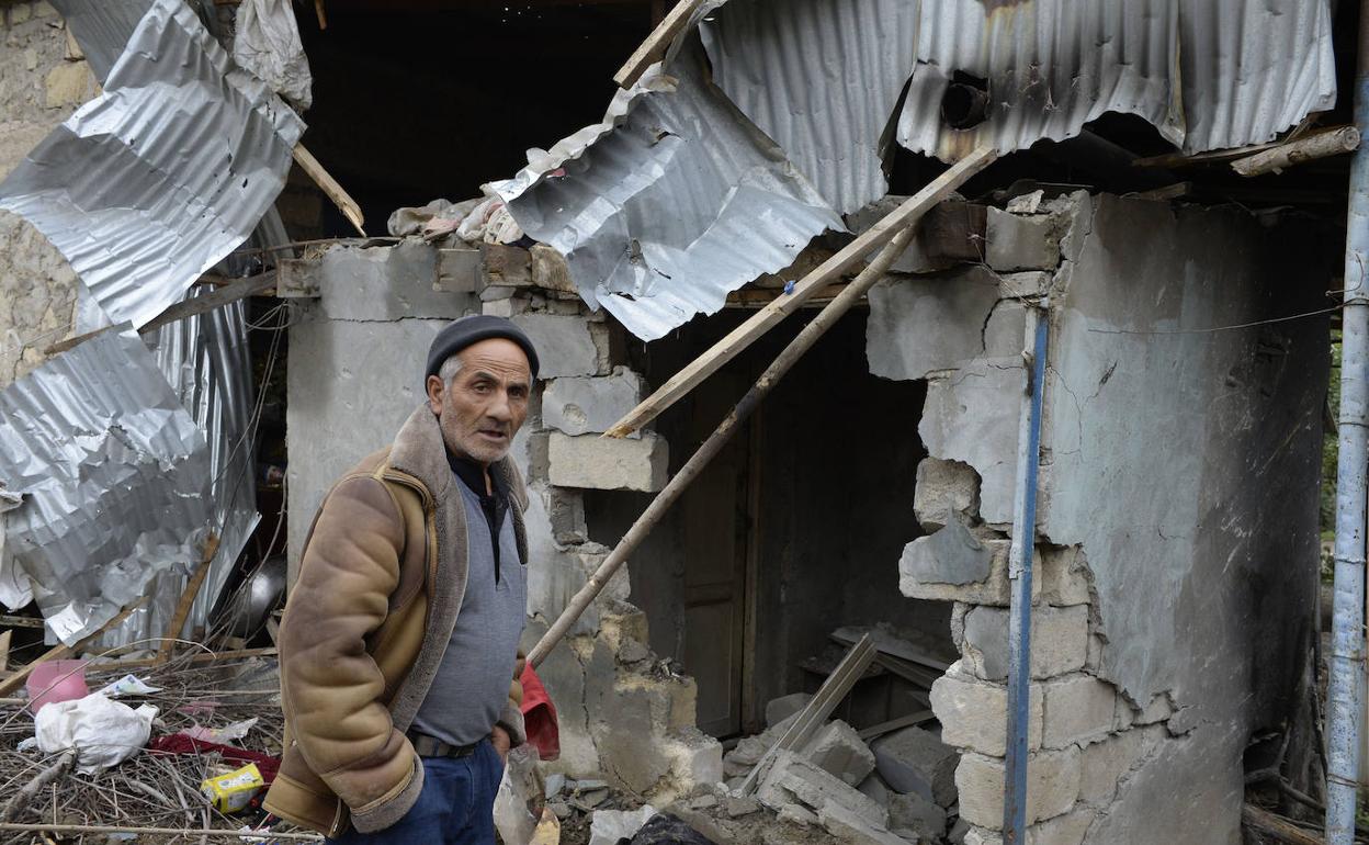 Un hombre busca objetos de valor en su casa destrozada. 