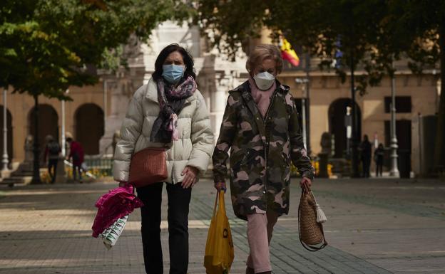 Dos mujeres con mascarilla pasean por Pamplona. 