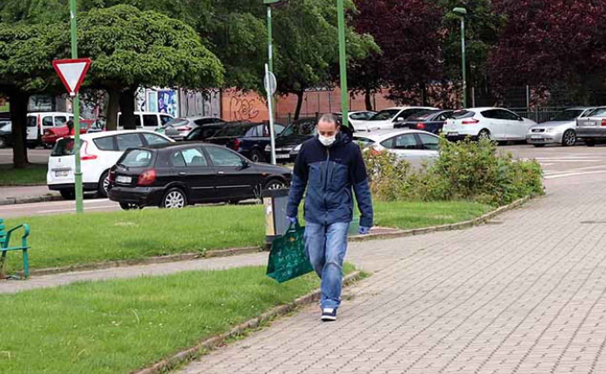 Un hombre camina por las calles de Burgos con mascarilla. 