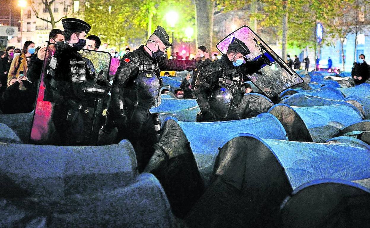 Agentes levantan las tiendas de campaña instaladas en la céntrica plaza de la República, en una operación en la que emplearon gases lacrimógenos.