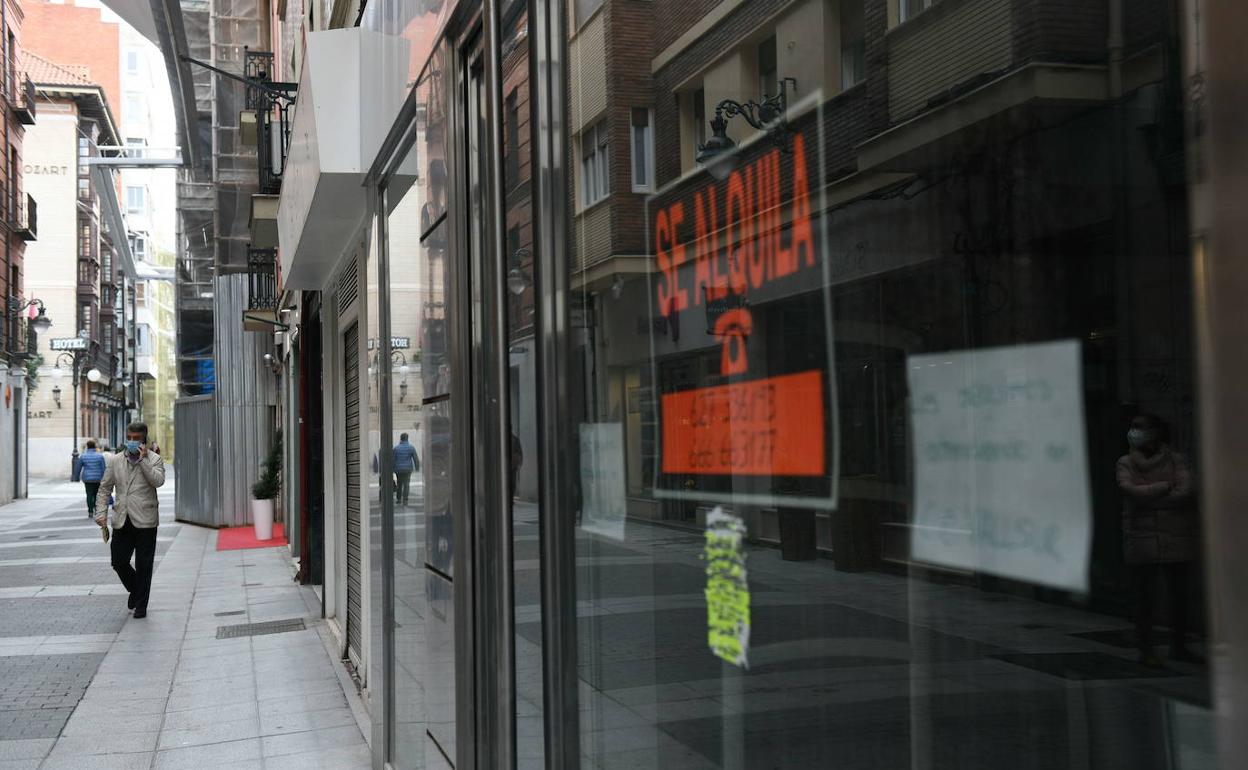 Ciudadanos paseando frente a comercios cerrados en Valladolid.