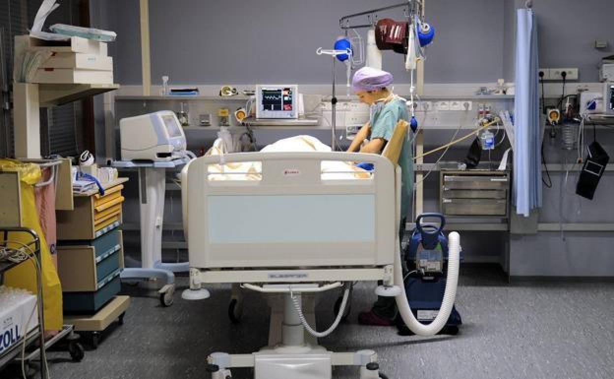 Una enfermera cuida de un paciente en una sala de recuperación. 