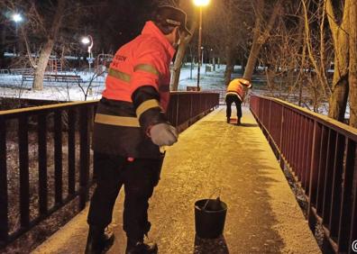 Imagen secundaria 1 - Voluntarios de Potección Civil acondicionan el pavimento helado para evitar accidentes en Burgos.