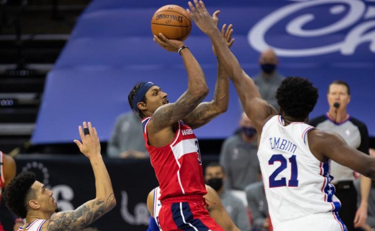 Bradley Beal lanza a canasta con la oposición de Joel Embiid. 