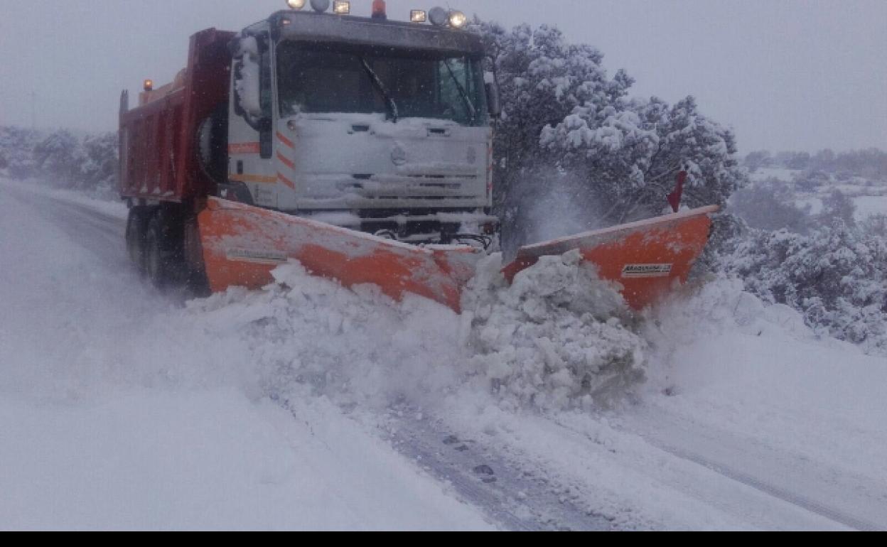 Una máquina quitanieves limpia una carretera de la provincia. 