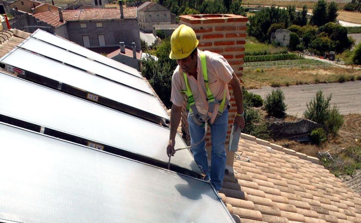 Un operario instala paneles fotovoltáicos en una vivienda de Santiago del Arroyo (Valladolid). 