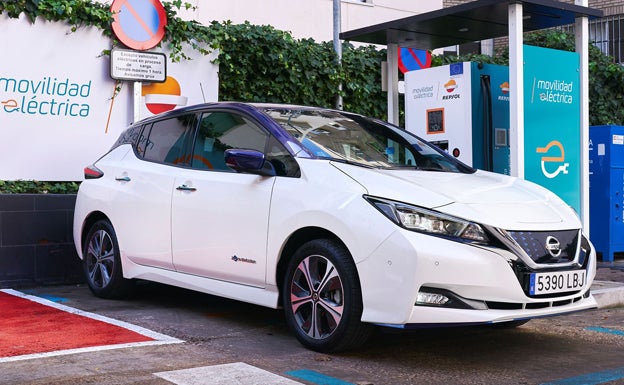 Vehículo eléctrico Nissan reposta en una estación de servicio Repsol. 