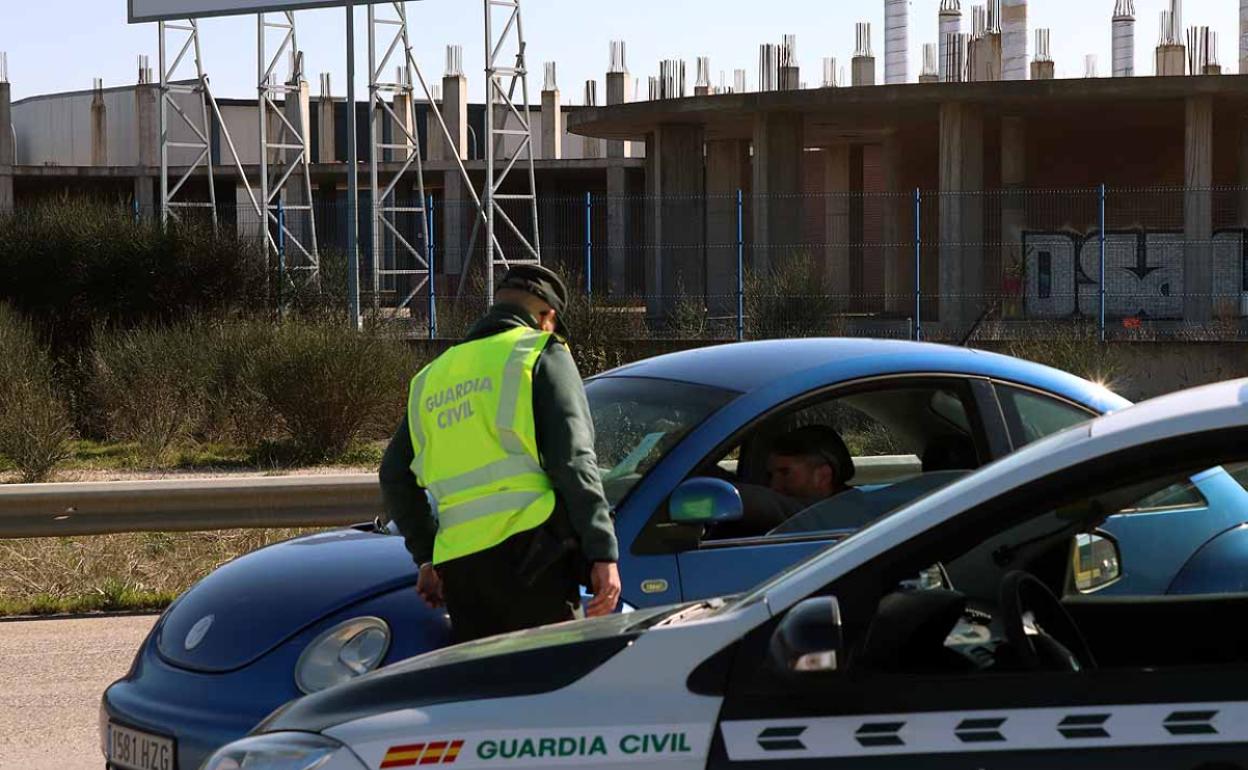 Un conductor apoya en la luna del coche la documentación para que la observe el agente de la Guardia Civil en Burgos. Protocolos de pandemia. 