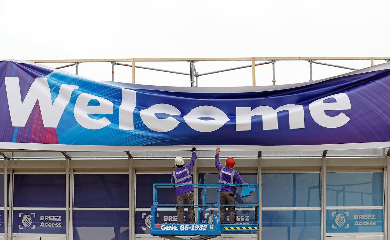 Operarios recogen los carteles de entrada al MWC de Barcelona.