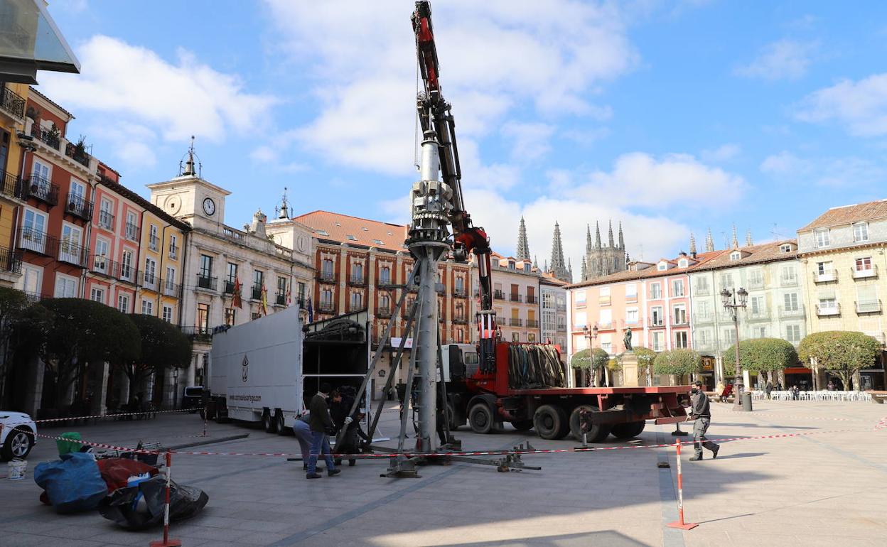 Operarios de le empresa Carruseles Ortega instalan el tiovivo en la Plaza Mayor este lunes.