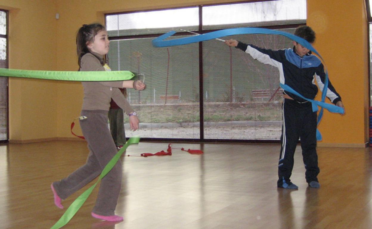 Dos niños practican con cintas. 