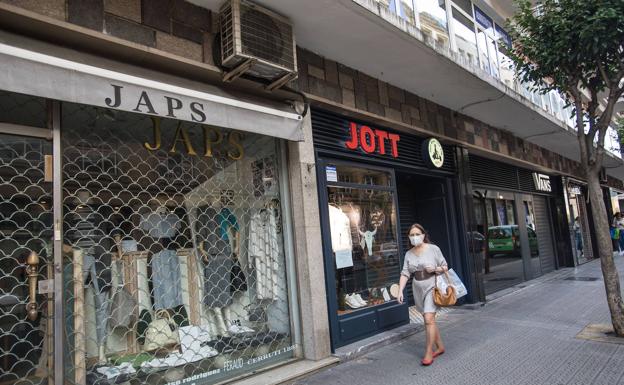 Una mujer frente a las tiendas cerradas en Bilbao por las restricciones.