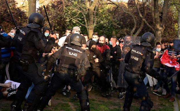 Los antidisturbios cargan en la plaza de la Constitución de Vallecas, en Madrid.