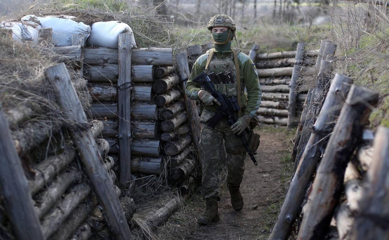 Un soldado ucraniano patrulla en la trinchera levantada en la frontera con Rusia.