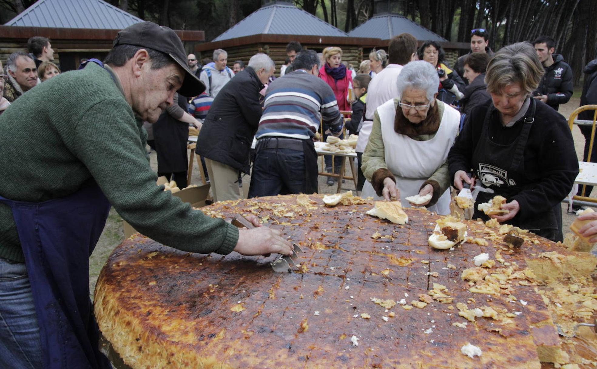 Corte de la tortilla gigante que se sirve el Día de la Vieja en Laguna de Duero.