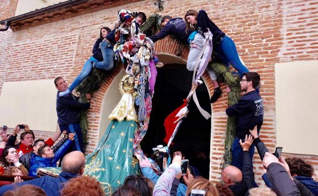 La Virgen cruza la guirnalda de pañuelos sostenidos por los quintos.