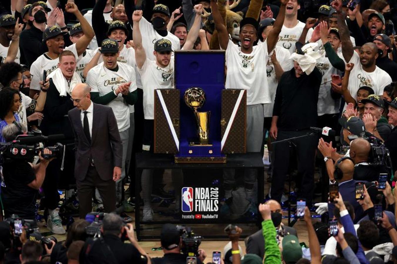 Los jugadores de los Milwaukee Bucks celebran el triunfo en torno al trofeo.