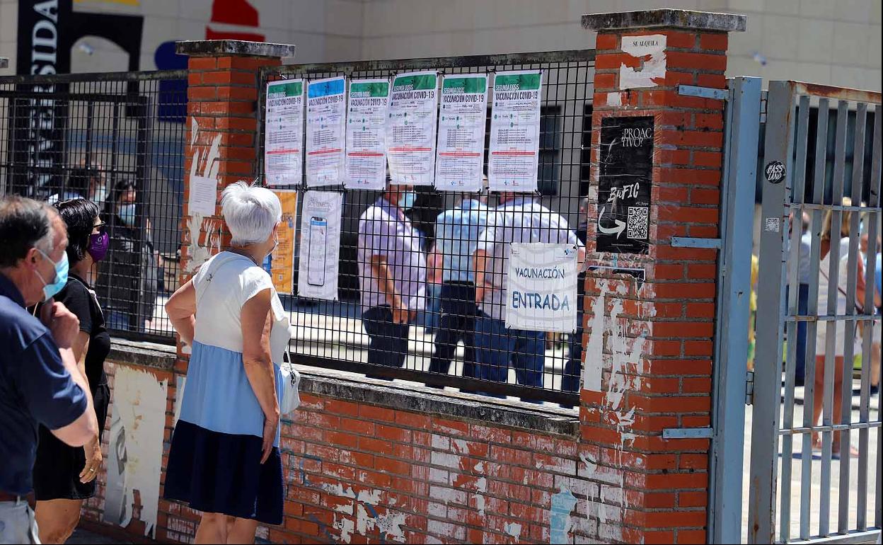 Una mujer mira las convocatorias de vacunación en el polideportivo de la UBU.