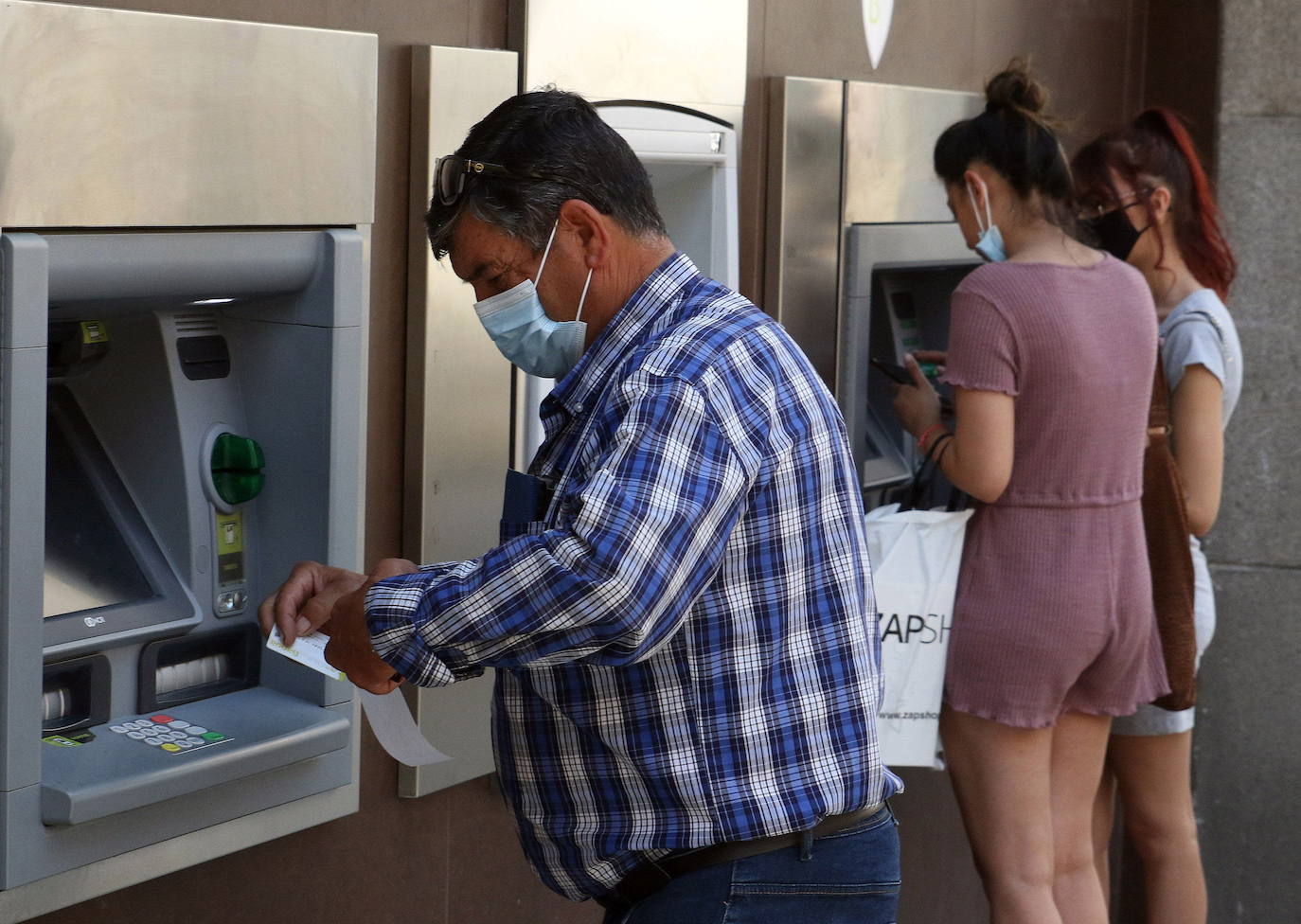 Personas usando un cajero automático. 