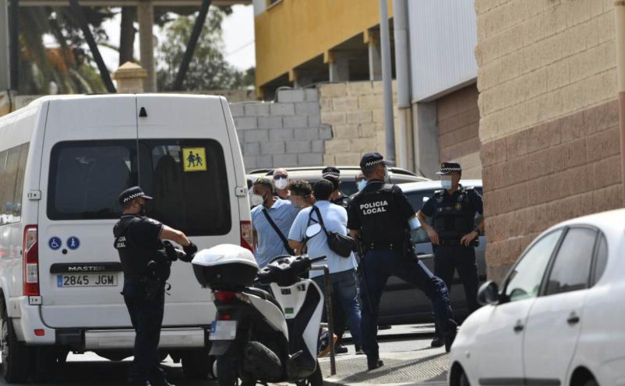 Varios agentes y vehículos de la Policía Local de Ceuta acompañan a menores no acompañados hacia una furgoneta 