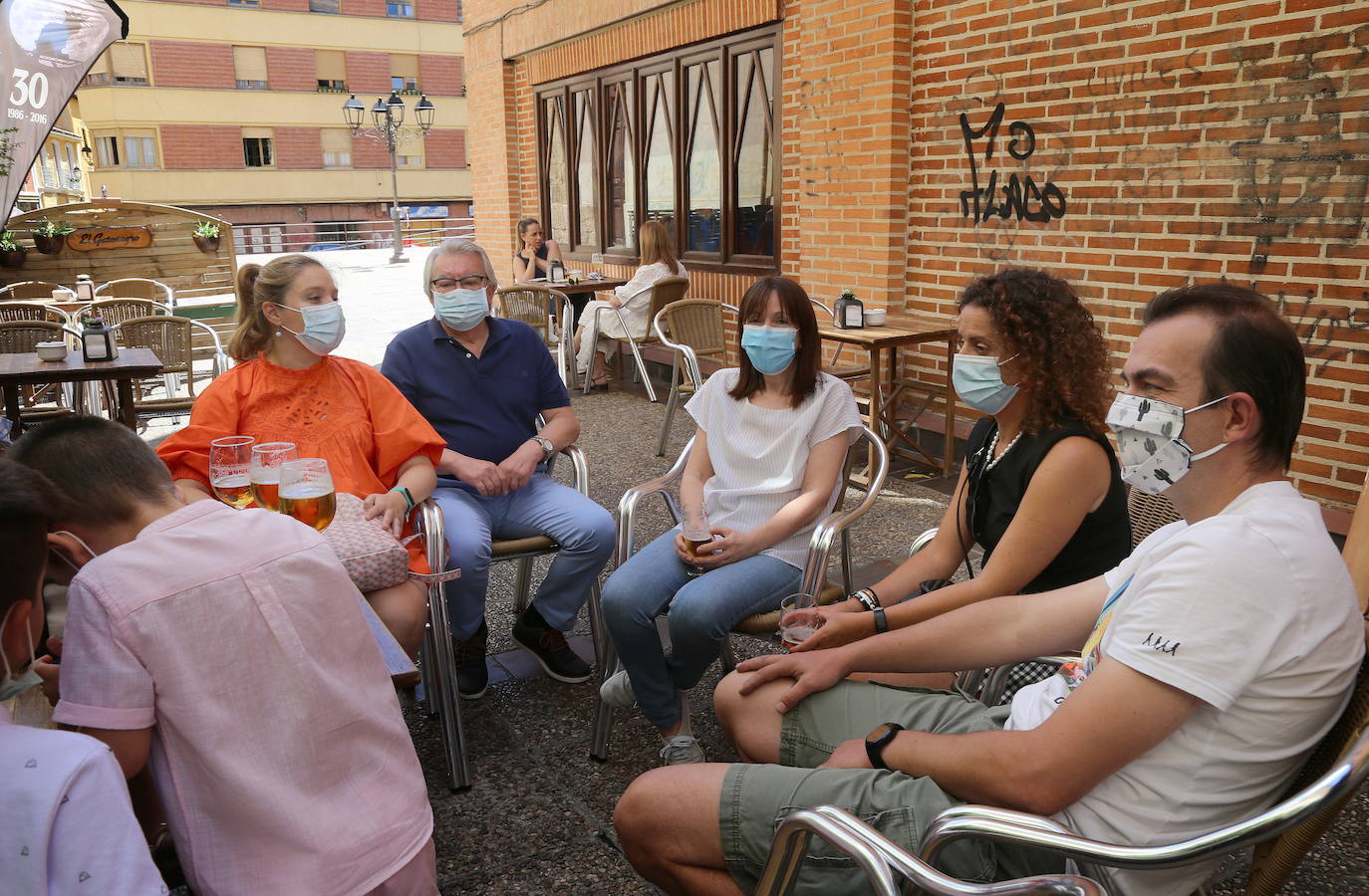 Clientes, con mascarilla en la teraza de un bar de Palencia.