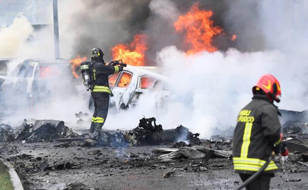 Los bomberos sofocan el incendio provocado por el avión al estrellarse en Milán.